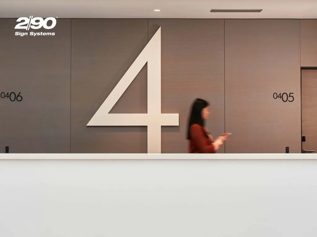 Woman walking in hallway appearing blurred with "290 Sign Systems" in the top left corner