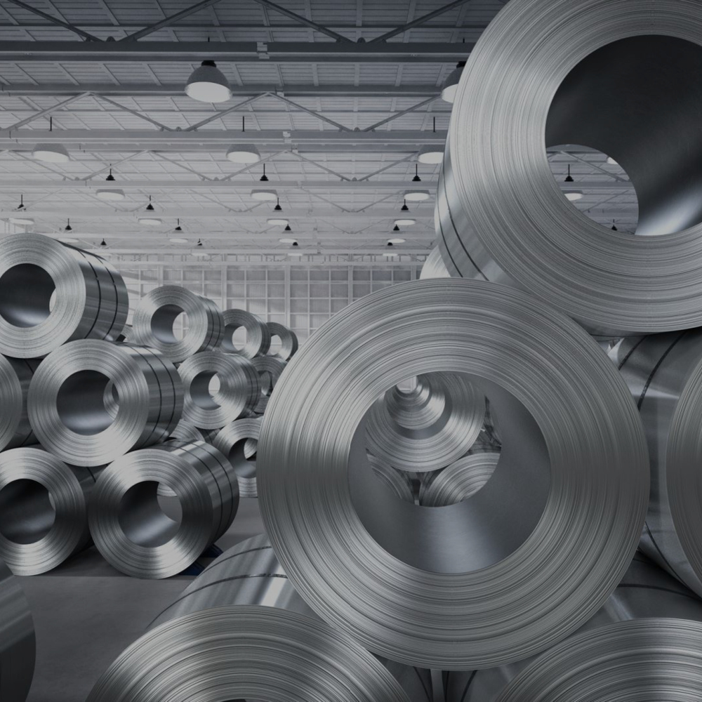 Image of rolled steel stacked within a warehouse building.