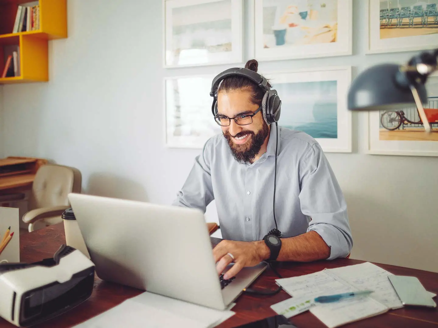 Man working from home in office with computer and headphones