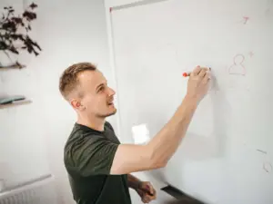 A businessman uses a whiteboard to learn customer experience research.