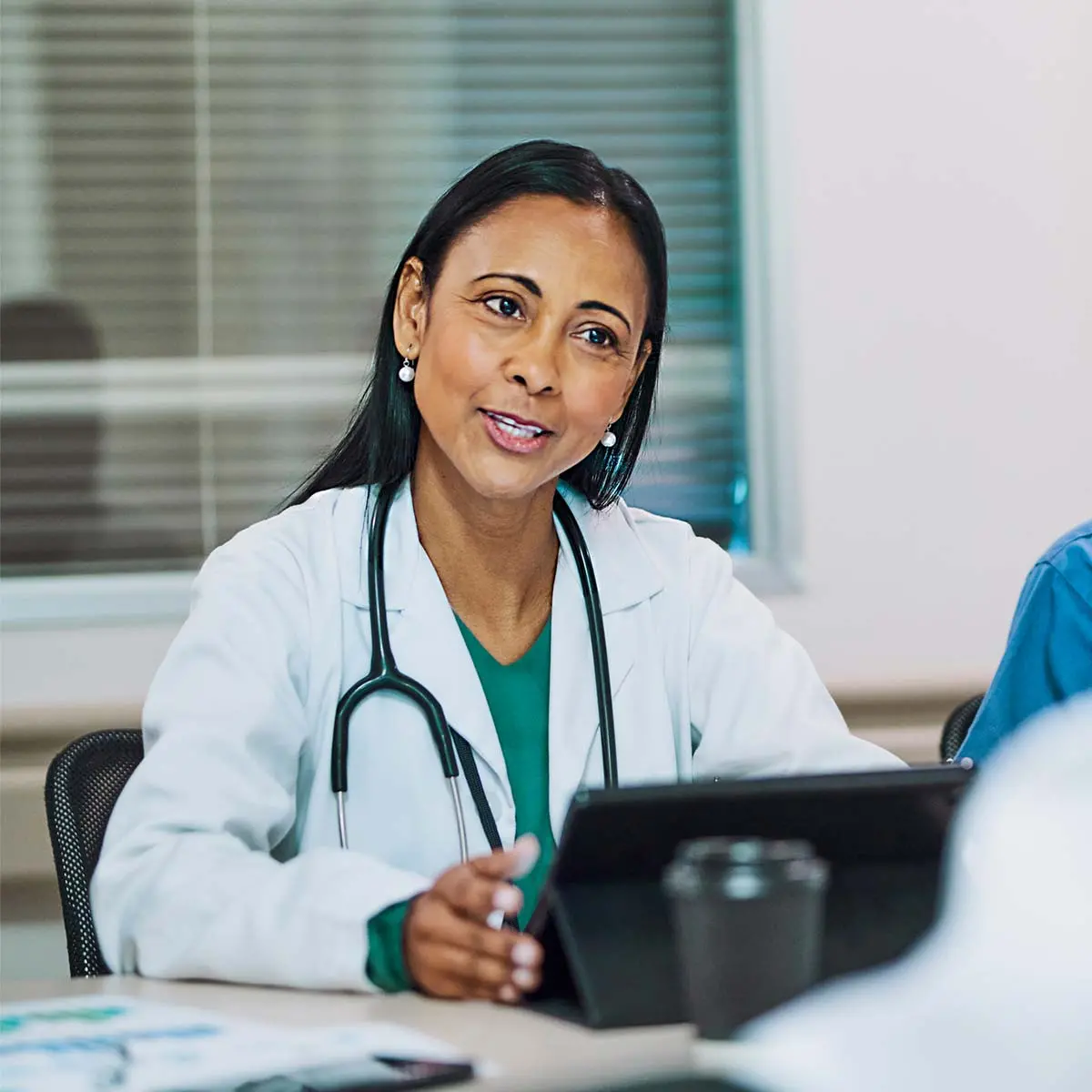 Care provider meeting with patient with tablet