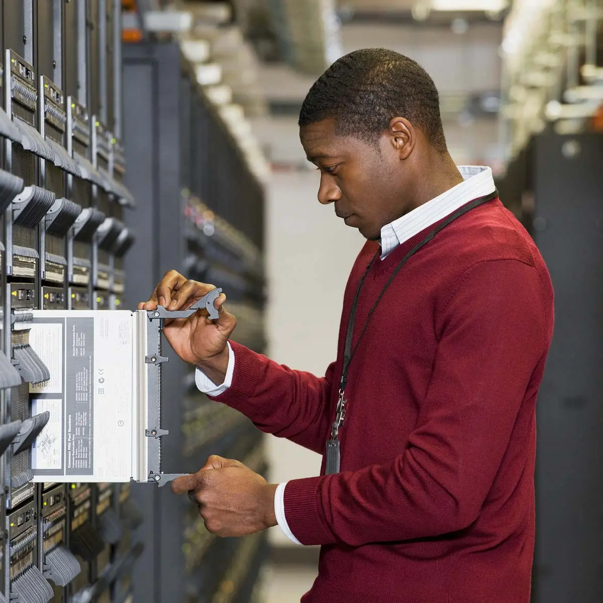 IT managed services provider in red sweater removing a server