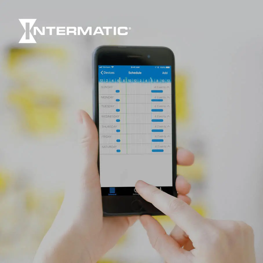 A person interacting with Intermatic's Ascend mobile scheduling application. On the screen is a week-long schedule, starting with Sunday at the top of the list and Saturday at the bottom of the list, and with on/off time slots set for each day. Centered and in front of the background image is text that reads "Intermatic: Building Connected Experiences From the Ground Up"