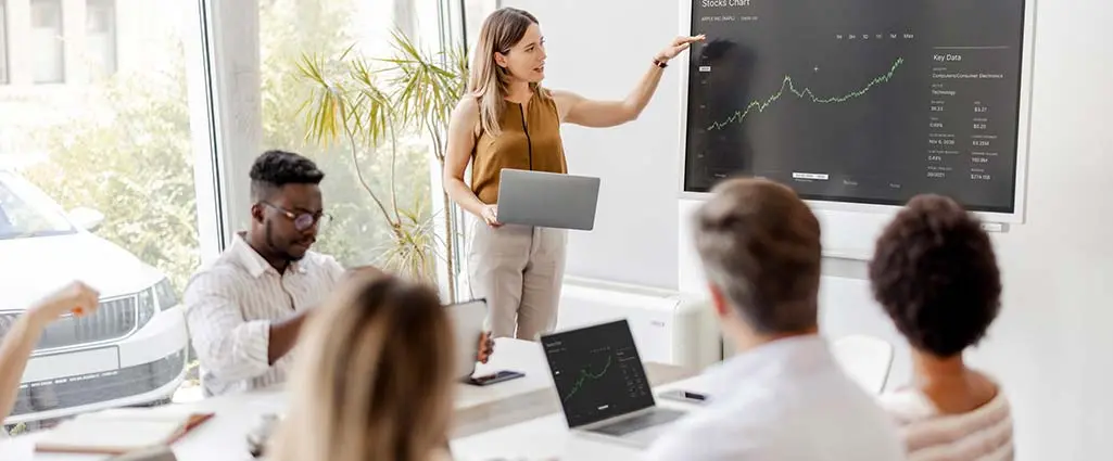 Presentation in Multi-Ethnic Office Conference Room. Meeting of Diverse Young Entrepreneurs, Specialists, Talking, Using TV for infographics. Businesspeople Develop e-Commerce Startup