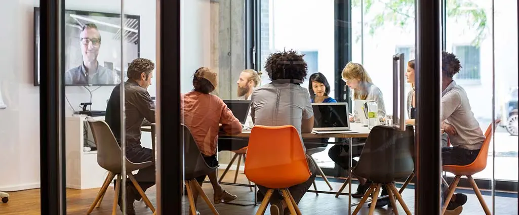 Multi-ethnic business people video conferencing in board room at office