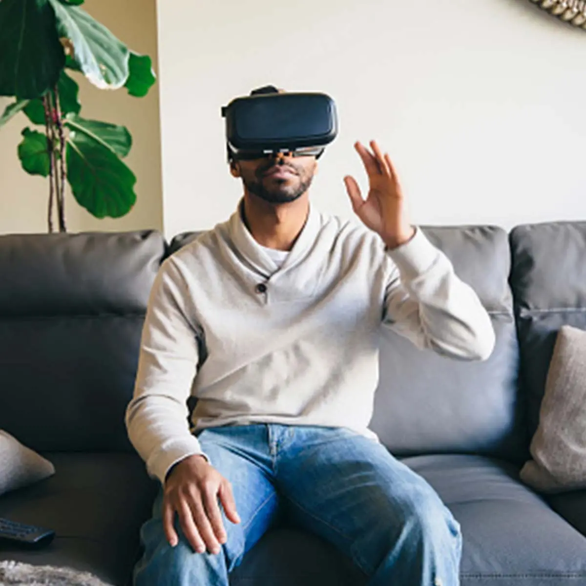 Man sitting on couch using VR headset