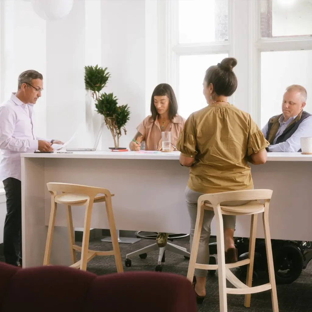 A group of four Vervint employees working together around a standing desk.